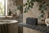 Charcoal soap bar on a bathroom shelf with hanging eucalyptus