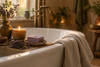 Lavender soap bar on the edge of a bathtub with a candle and towel